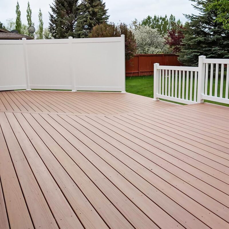 A durable, low-maintenance composite deck provides an inviting outdoor space for relaxation and entertaining. This project is paired with a matching white vinyl fence that offers both privacy and a clean, cohesive look.  Composite decking stands up well to the elements and requires minimal upkeep compared to wood. The vinyl fencing provides security and a barrier from neighbors without the need for painting or staining.