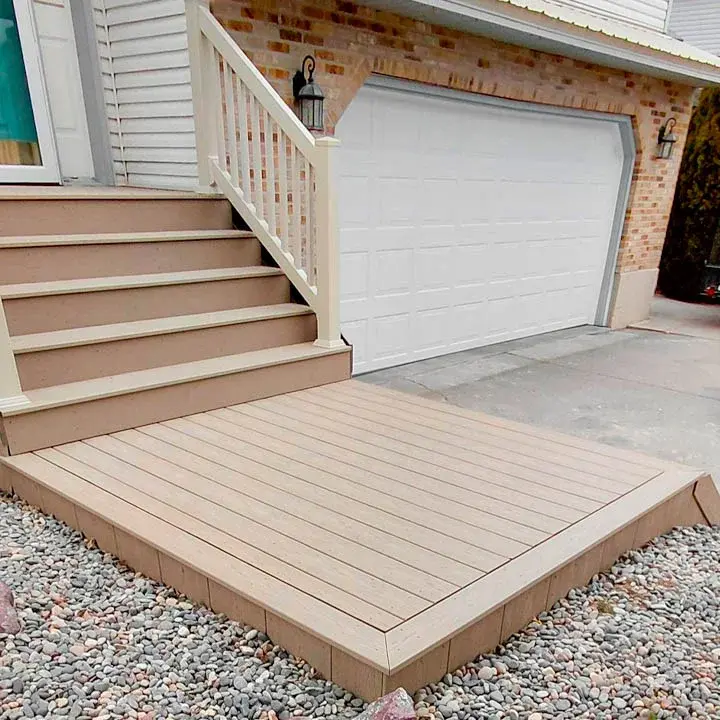 A multi-level raised deck featuring dark wood framing, dark decking, and high-contrast white vinyl railings and stairs.