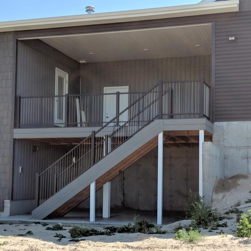 A durable, elevated outdoor living space that seamlessly connects to the home's architecture. This project features high-performance composite decking, a dark bronze aluminum cable railing system, and a structural stair tower for safe, elegant access. Integrated recessed lighting in the soffit creates an inviting ambiance for evening use, while the covered design offers year-round protection.