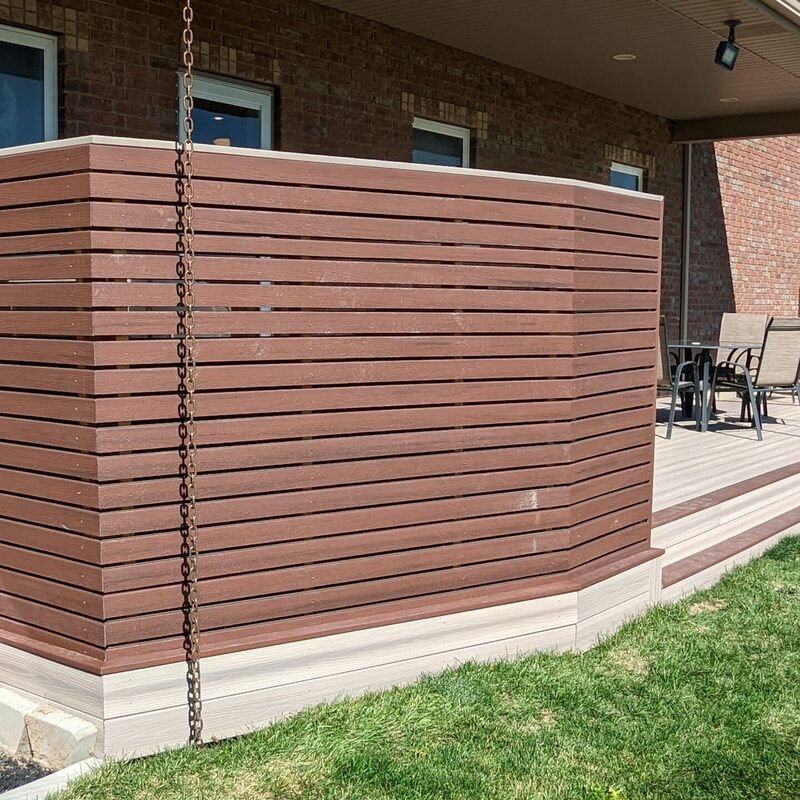 Expand your outdoor living possibilities with this custom deck by DeckPro LLC, which combines rustic elements with modern materials. We installed low-maintenance composite decking in a warm brown tone and paired it with a unique railing system that features natural wood posts and integrated wire mesh infill panels. This design provides a sturdy and stylish transition from your home to your backyard, even in snowy conditions, thanks to durable, low-maintenance composite materials.