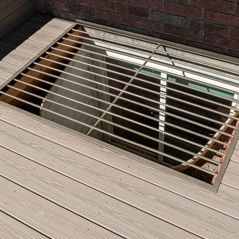 Extend your multi-level outdoor living with this massive backyard transformation by DeckPro LLC, pictured here in a transition from winter to spring. We took a multi-story house with uncompleted areas and rough dirt work and created a luxurious, fully-functional sanctuary. The expansive new structure features an elevated two-story composite deck with defined zones, including covered upper living complete with recessed lighting, integrated privacy screening, and massive, wide connecting stairs that seamlessly connect to a stamped concrete lower level. We installed high-quality, durable composite decking and paired it with safe and sophisticated black vertical perimeter railings. The sturdy retreat includes a beautifully integrated hot tub surround and custom under-deck enclosed storage, optimizing multi-directional natural views for a tranquillity sanctuary perfect for any large property.