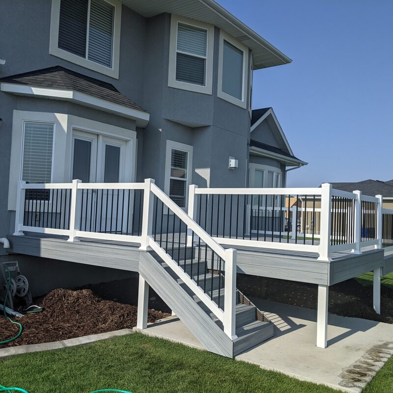 Expand your outdoor living possibilities with this extensive multi-level deck project by DeckPro LLC. We installed high-quality, low-maintenance composite decking in a warm brown tone and paired it with sophisticated dark metal perimeter railings. For the ultimate in style and function, this design features unique curved black balusters on the upper deck and a massive, inviting staircase that seamlessly connects the two levels, creating a sturdy and stylish retreat perfect for relaxation or entertaining.