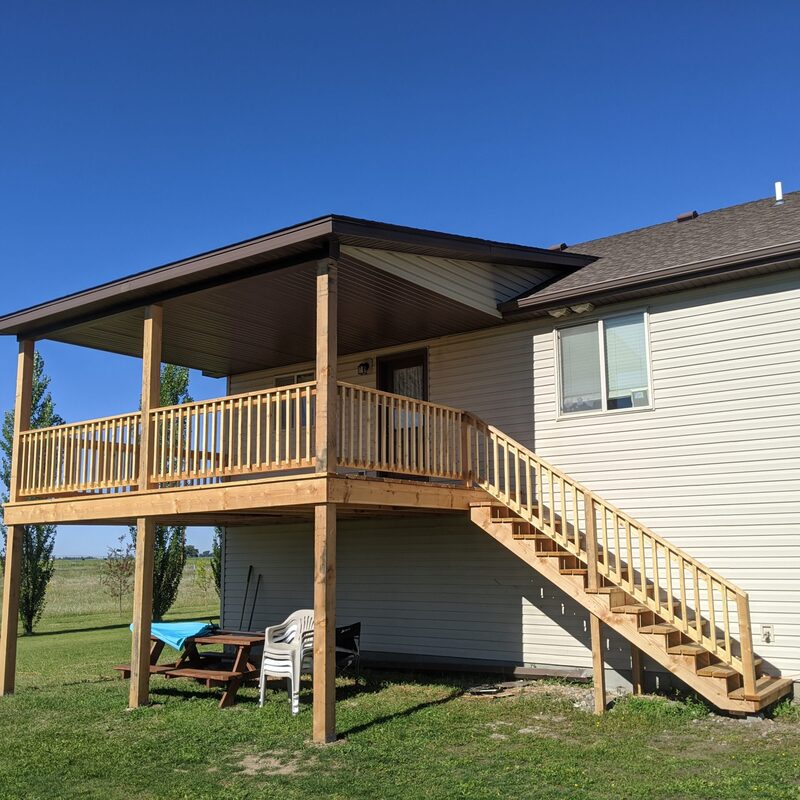 Extend your multi-level outdoor living with this cozy raised deck and patio combination by DeckPro LLC. We installed high-quality, low-maintenance white perimeter railings to ensure safety without obstructing views. Perfect for relaxation or entertaining, this functional build transitions through a defined, massive and inviting set of stairs with contrasting composite planks leading to a custom stamped concrete lower level. Pictured on a beautiful day with distinct shadows cast across the deck boards, this sturdy retreat maximizes multi-directional natural views. Recessed lights in the vinyl pergola allow for extended evening use. Direct access is available via existing glass doors.