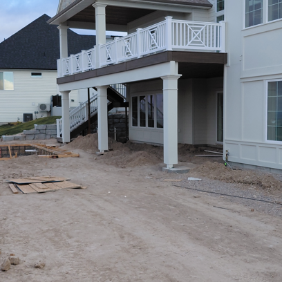 A structural exterior shot of a large-scale vinyl railing and deck installation by DeckPro LLC in Idaho Falls, ID. This view showcases the multi-story balcony and staircase integration on a new residential build.
