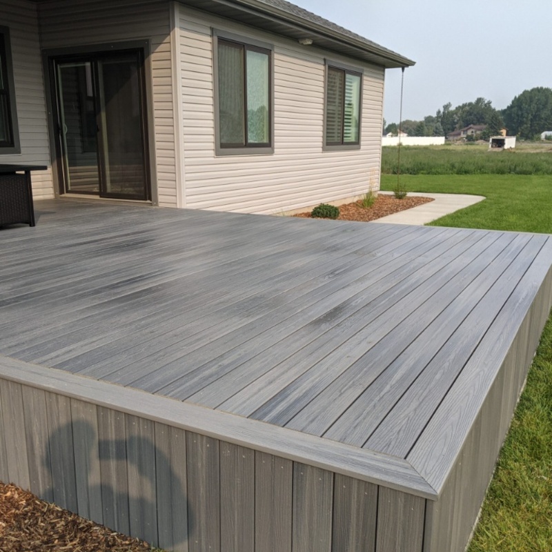 Expand your outdoor living space with this custom deck project by DeckPro LLC, designed to blend rustic charm with modern durability. This build features low-maintenance composite decking and a unique perimeter railing that combines natural wood posts with wire mesh infill panels. The functional design includes extensive built-in bench seating, making it an inviting retreat perfect for relaxing and taking in scenic, natural views.