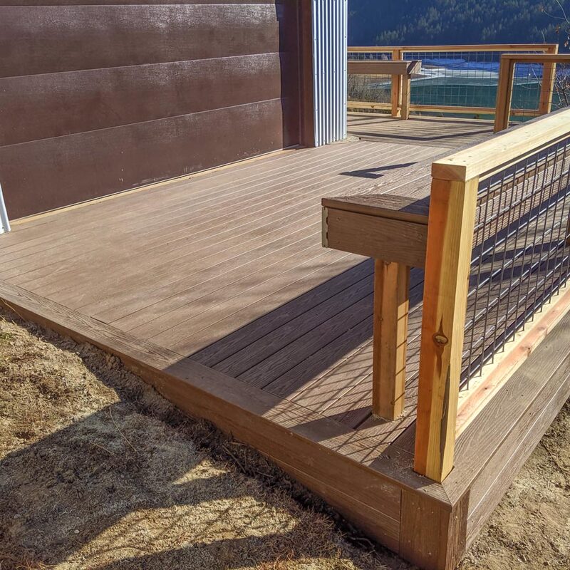 This custom DeckPro LLC project perfectly blends rustic character with modern durability. Featuring rich brown composite decking for low maintenance, the design is highlighted by a unique natural wood and industrial wire mesh railing. A custom built-in bench provides integrated seating without sacrificing space.