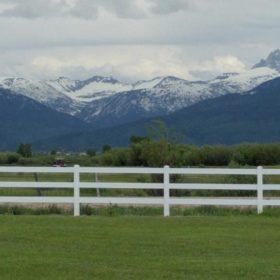 white fence with Teton Mountain in background.