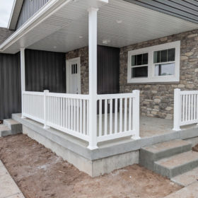 front patio with white railing and roof overhang..