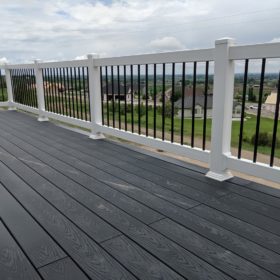 dark gray deck with black and white railing.