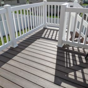 beautiful backyard deck with white railing.