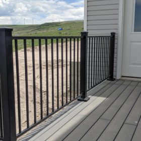 deck with black railing near wind mills.