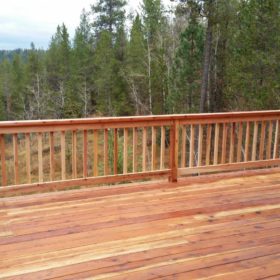 red wood deck with natural wood railing.